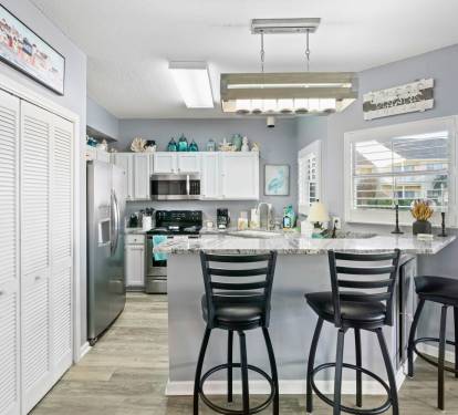 Your fully equipped kitchen features granite countertops and breakfast bar seating, perfect for preparing meals and casual dining together.