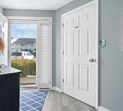 Step into your coastal retreat where soft blue walls welcome you home. The bright entryway flows seamlessly to your outdoor space.