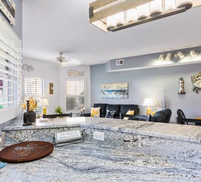 Your open-concept living space features stunning granite countertops perfect for meal prep, while coastal decor creates a relaxing atmosphere.