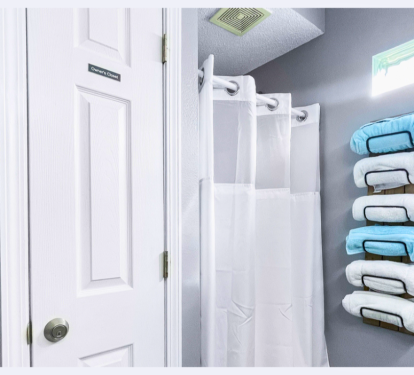 Step into your pristine bathroom where fluffy towels await on stylish wall racks, and fresh linens make every shower feel luxurious.
