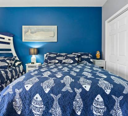 Dive into coastal dreams in your charming blue bedroom, where nautical fish patterns and ocean-inspired decor create the perfect seaside retreat.
