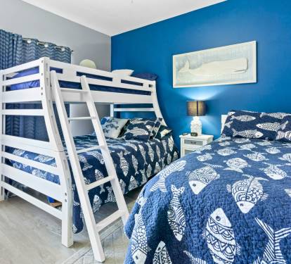 Drift off in this ocean-themed bedroom where nautical blues wrap you in seaside serenity and cozy bedding promises restful nights.
