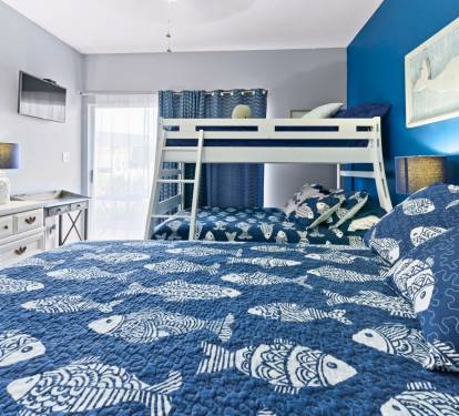 Your family bedroom features a king bed and bunk bed with nautical-themed bedding, creating the perfect space for everyone to rest comfortably.