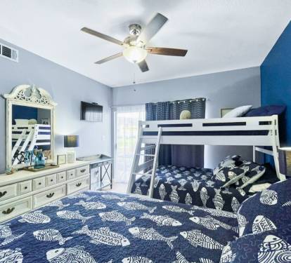 Drift off to sleep in this coastal-themed bedroom featuring comfortable beds and a charming bunk bed perfect for family adventures.