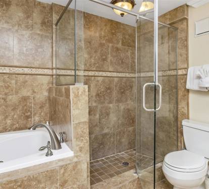 Unwind in your luxurious marble bathroom with a deep soaking tub and spacious glass shower after exploring the day.