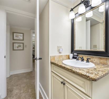 Your private bathroom features elegant granite countertops, classic vanity lighting, and quality fixtures for a comfortable, spa-like experience.