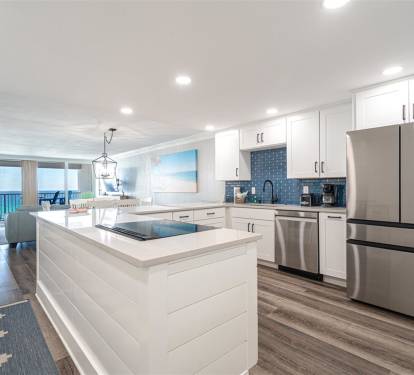 Your gourmet kitchen features sleek white cabinetry, stainless steel appliances, and a spacious island where you can cook while enjoying stunning ocean views.