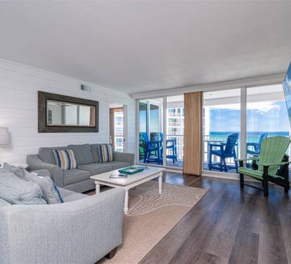 Unwind in your stylish living space with plush seating and stunning ocean views through floor-to-ceiling windows.