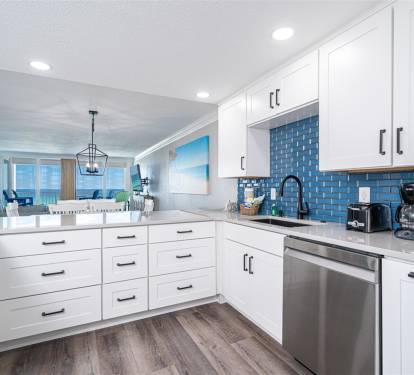 You'll love cooking in this bright, modern kitchen with stunning blue tile backsplash and ocean views beyond.