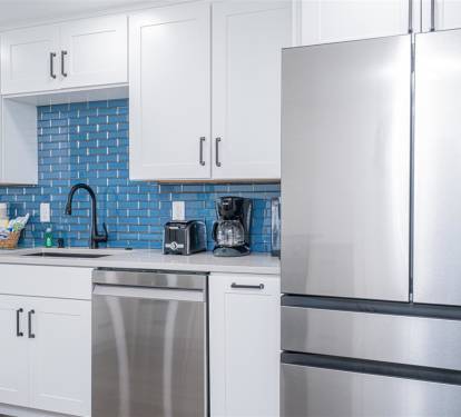 Your fully equipped kitchen features stainless steel appliances and stunning blue tile backsplash, perfect for preparing meals during your stay.