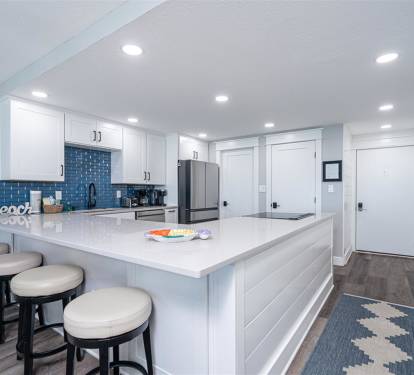 Your modern kitchen features white quartz counters, blue subway tile backsplash, and stainless appliances for effortless meal prep.