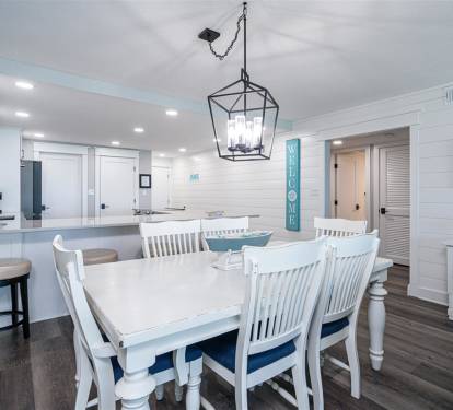 Gather around this bright dining space where white coastal charm meets modern comfort for memorable meals together.