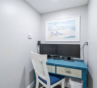 Your dedicated workspace awaits with dual monitors and a charming beach-themed desk, perfect for remote work or planning your coastal adventures.