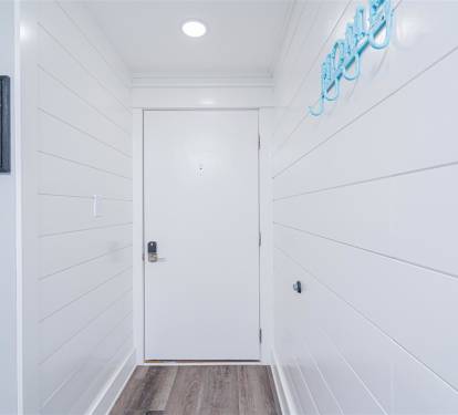Step into your coastal retreat through this bright, welcoming entryway with charming shiplap walls and cheerful nautical touches.