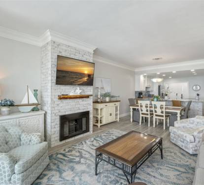 Unwind in your elegant coastal retreat, where a cozy fireplace and open living flow perfectly into your fully equipped kitchen—ideal for memorable evenings together.