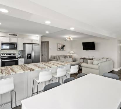 Relax in your spacious open-concept living area with a modern kitchen, comfortable seating, and entertainment center perfect for your getaway.