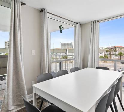 Gather around your spacious dining table with panoramic windows showcasing the coastal neighborhood, where natural light fills every shared meal.