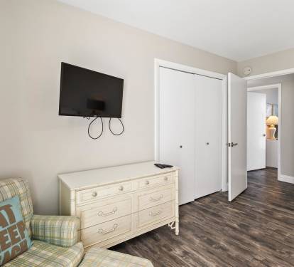Relax in your cozy living space with plaid seating, wall-mounted TV, and ample storage in this comfortable dresser.