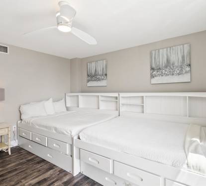 Sleep comfortably in this charming bedroom featuring twin beds with built-in storage and soothing neutral décor that creates your perfect retreat.