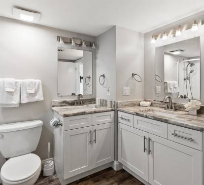 Pamper yourself in this luxurious bathroom with double vanities, marble countertops, and fresh white towels waiting for your arrival.