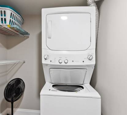 Your private laundry closet features a stacked washer and dryer with convenient shelving for all your vacation essentials.