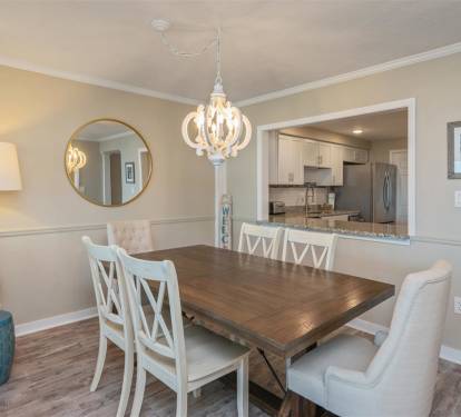 Gather around your elegant dining table for memorable meals, with warm pendant lighting and an open view to your fully-equipped kitchen.