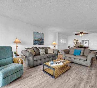 Settle into this spacious living room where coastal colors and comfy seating create your perfect retreat for relaxation.