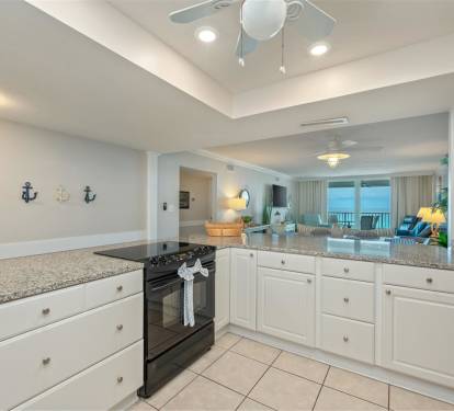 Your gourmet kitchen features granite countertops, full appliances, and nautical touches, opening to a living space with stunning sea views.