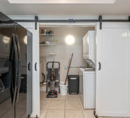 Your fully-equipped kitchen features modern appliances and a convenient laundry closet with sliding barn doors for seamless meal prep and easy cleanup.