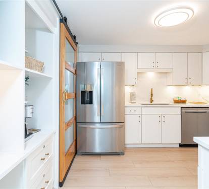 Your spacious kitchen awaits with sleek stainless appliances, pristine white countertops, and thoughtful storage - perfect for cooking memorable meals during your stay.