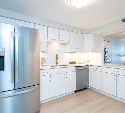 Step into your pristine modern kitchen featuring sleek white cabinetry, stainless steel appliances, and elegant countertops perfect for culinary adventures.