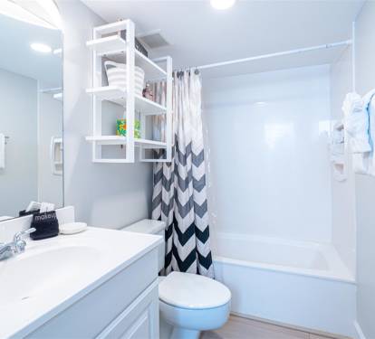 Refresh in your bright, modern bathroom with thoughtful touches like fluffy towels, clever storage, and a spacious shower-tub combo.