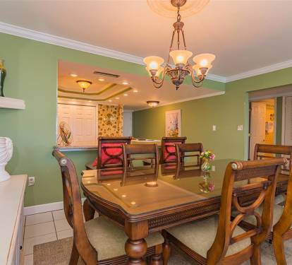 Your elegant dining space features beautiful green walls, warm chandelier lighting, and seating for memorable meals together.