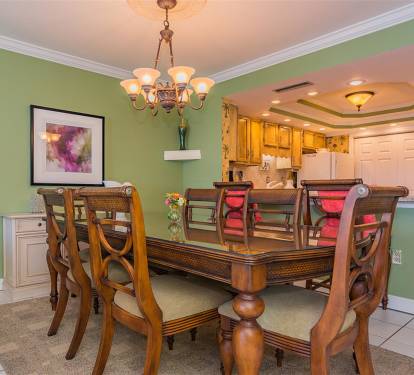 Your elegant dining room features a stunning chandelier, rich wood table for eight, and charming green walls creating the perfect space for memorable meals.