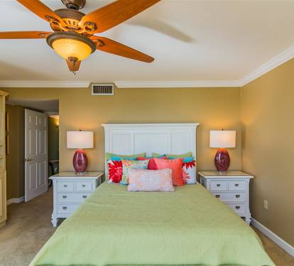 Unwind in your elegant bedroom featuring a comfortable bed, stylish fan, and built-in entertainment center for relaxing evenings.