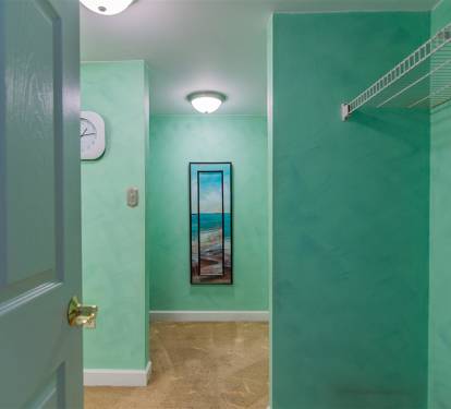Your private laundry space features calming turquoise walls and convenient storage to keep your vacation wardrobe fresh.