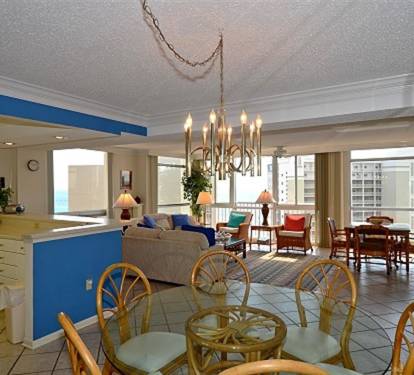Your spacious open-concept suite invites relaxation with bright living areas, elegant chandelier lighting, and stunning city views through floor-to-ceiling windows.