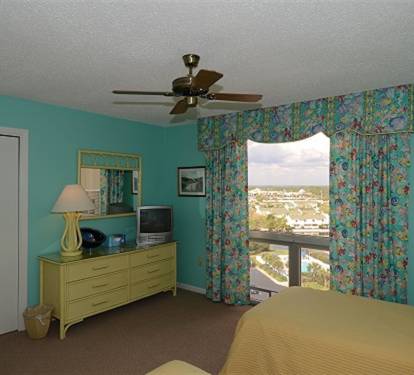Wake up to stunning city views from your bright, tropical-themed bedroom with comfortable furnishings and modern amenities.