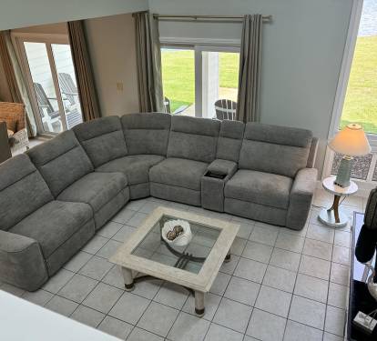 Sink into your spacious sectional sofa with stunning waterfront views through glass doors leading to your private outdoor seating area.