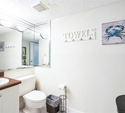 Your coastal-themed bathroom features warm nautical touches, with a convenient towel hook and vanity mirror for your daily routine.