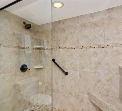 Step into your spacious walk-in shower with beautiful travertine tile and modern fixtures—your private sanctuary awaits.