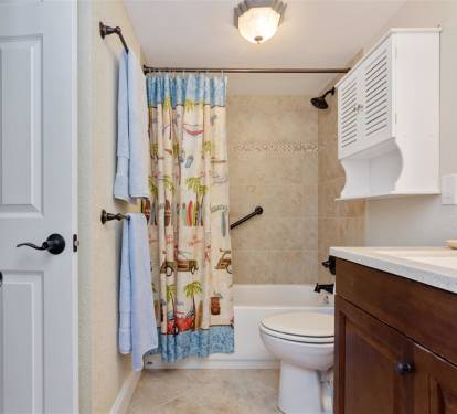 Your bathroom features a tub-shower combo with cheerful decor and essential amenities for your comfort.