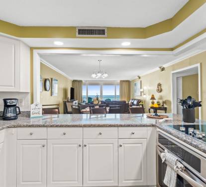 Your fully equipped kitchen features granite countertops and opens to a spacious living area with stunning ocean views.