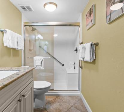 Step into your spacious bathroom featuring elegant granite countertops, a refreshing glass-enclosed shower, and plush towels awaiting your arrival.