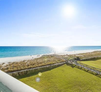 Stunning beachfront vista with pristine white sand, turquoise waters, and coastal walkways stretching along the shoreline.