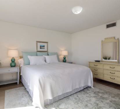 Sink into crisp white linens and let the soothing mint accents calm your mind in this thoughtfully designed bedroom retreat.