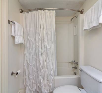Step into your pristine bathroom with plush white towels and a relaxing tub combo for unwinding after busy days exploring.