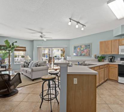Your spacious open-concept living awaits, where coastal blue walls meet warm wood accents and natural light floods through the skylight above.