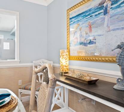 Enjoy your morning coffee at this charming coastal-themed dining nook, where ocean artwork and nautical touches create a serene beachside atmosphere.