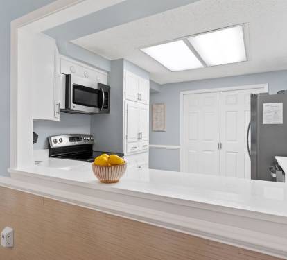 Your bright kitchen opens up with sleek white cabinets, modern appliances, and a spacious island perfect for cooking memorable meals.